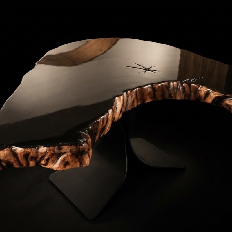Gloss black resin table with a live-edge rim, photographed against black