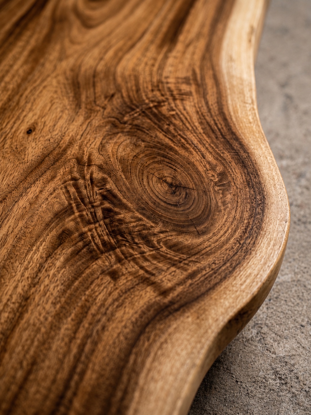 Close-up of swirling hardwood grain on a hand-finished live-edge table